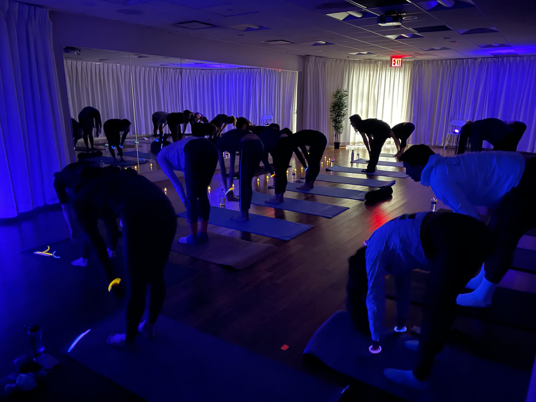 Yogis doing a Half Forward Fold in yoga studio at the Olivia